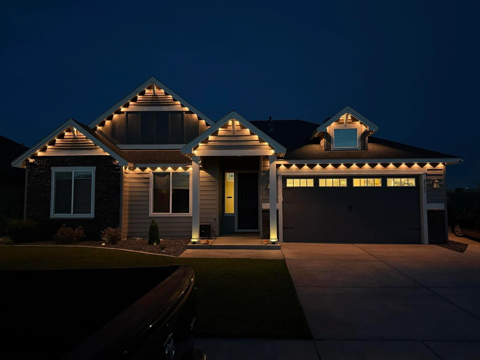 Craftsman home with warm white permanent lighting on every gable